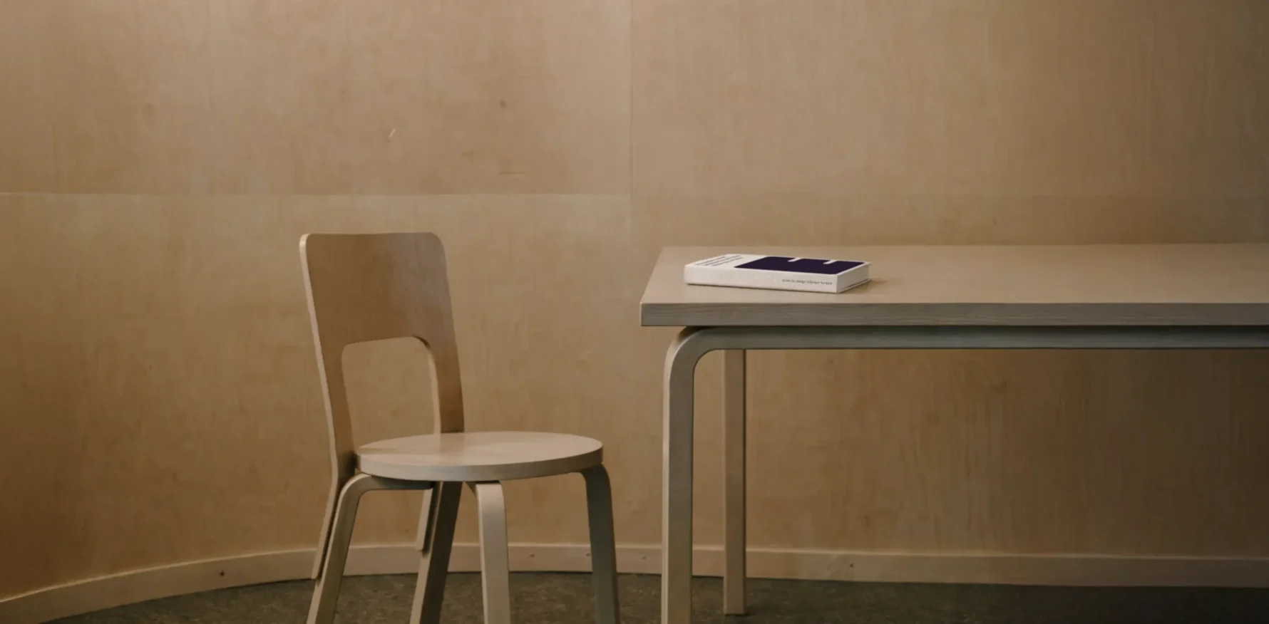 Support de formation en design intérieur durable présenté sous forme de livre dans un environnement minimaliste